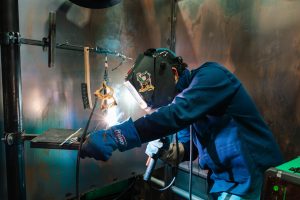 A welder practicing in a University training center