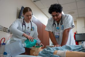 Two Goodwin Respiratory Care students practice CPR on a manikin