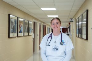 A blonde woman wearing white scrubs and a stethoscope