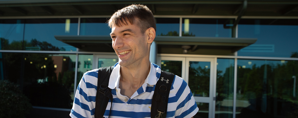 student smiling in front of goodwin university