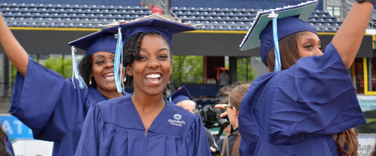 Two graduates holding flags and smiling