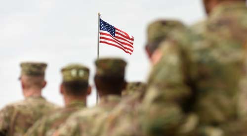 soldiers marching with the American flag