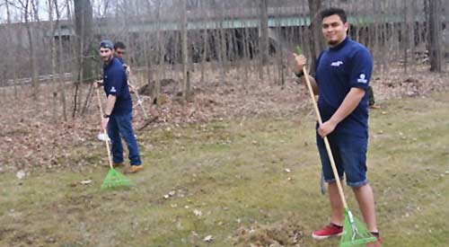Two students raking at a volunteer opportunity