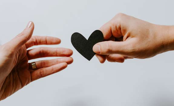black heard cutout passed between hands