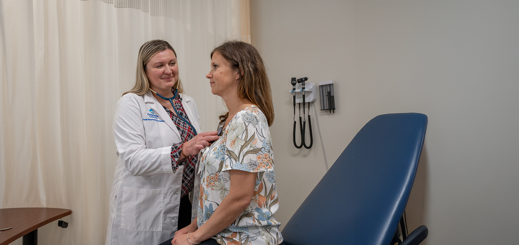 Goodwin University FNP student using a stethoscope on a patient