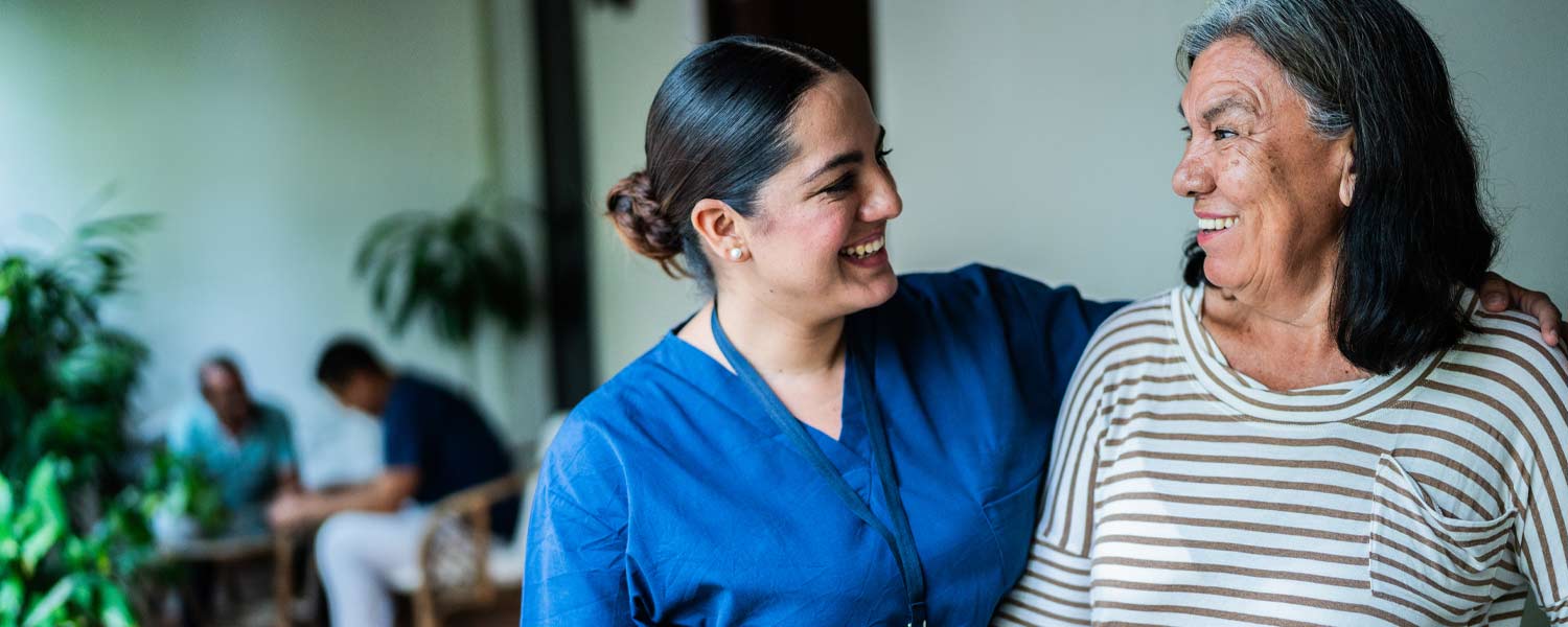 Patient care associate with arm around patient
