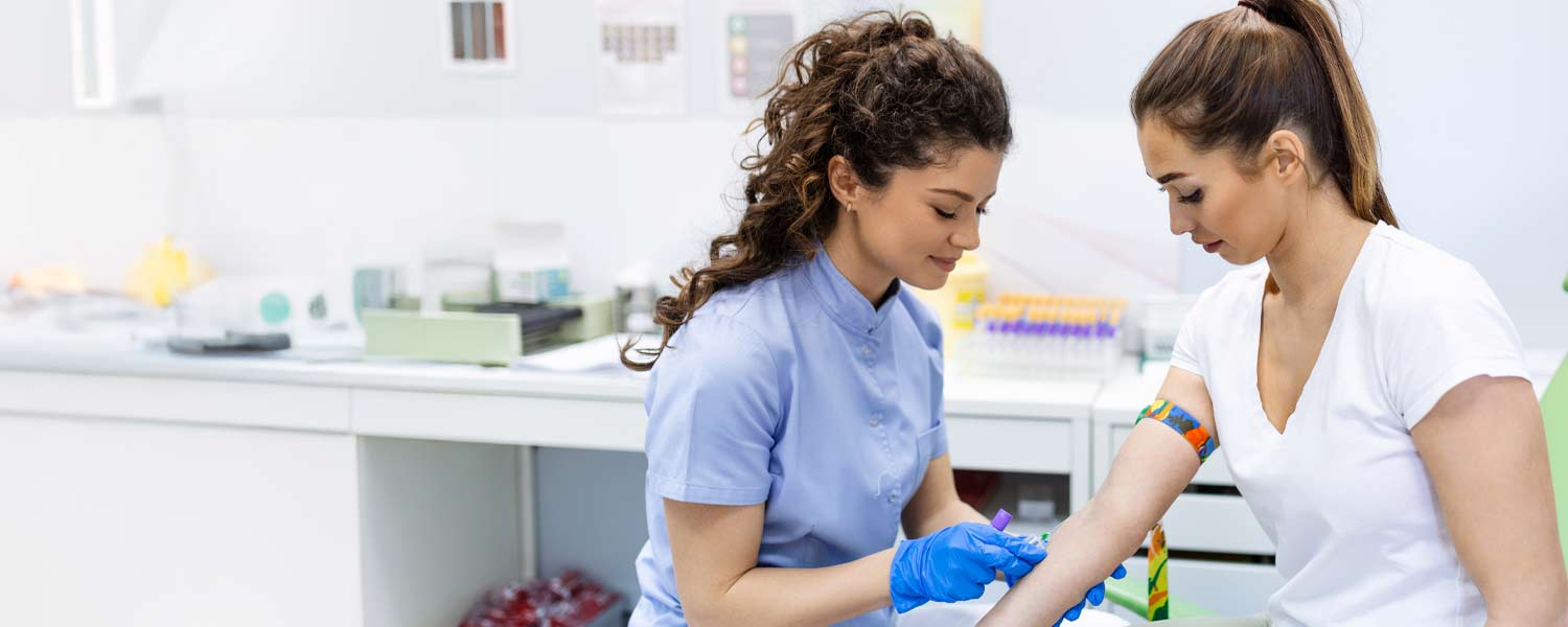 Phlebotomist drawing blood from a patient